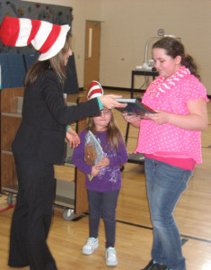News 8's Lisa Klein, left, presents reading prizes to Rose Arndt, right, a fourth-grader, and Kaitlyn Duchow, center, a kindergartener.